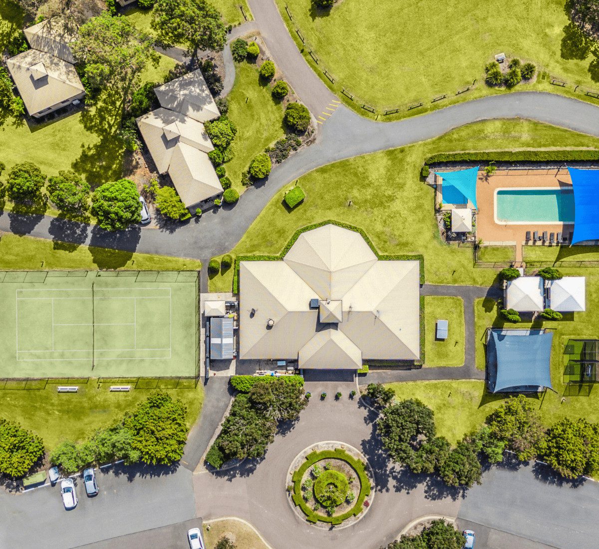 Overhead drone shot of facilities at Leisure Inn Pokolbin Hill including tennis court, pool, bbq area, table tennis table, kids playground